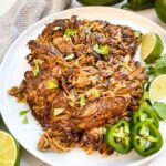 Seared Instant Pot Pork Carnitas on a white plate with jalapeno and cilantro.