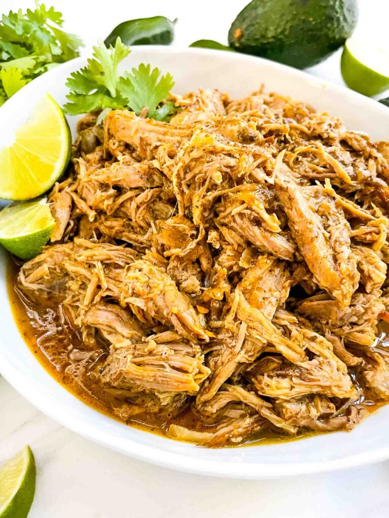 A white bowl full of shredded Instant Pot Pork Carnitas.