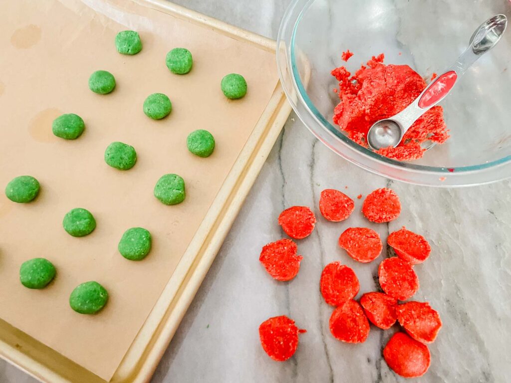 The dough being portioned into little balls and being put on a baking sheet.