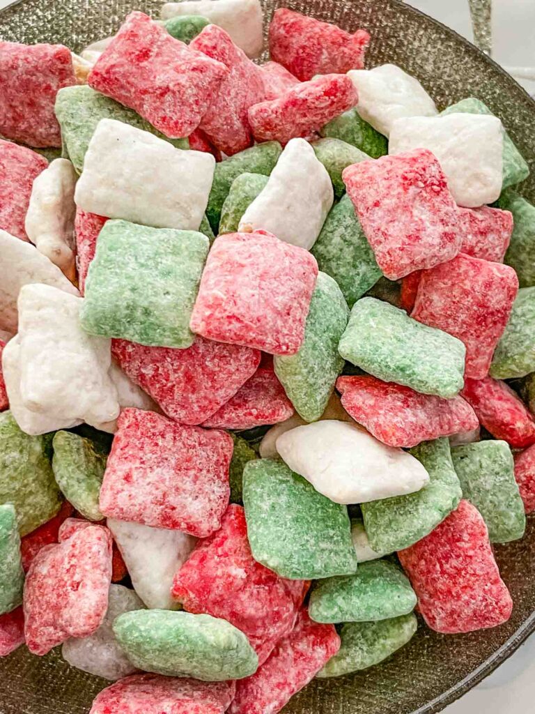 Close view of red, white, and green Holly Jolly Christmas Puppy Chow in a bowl.