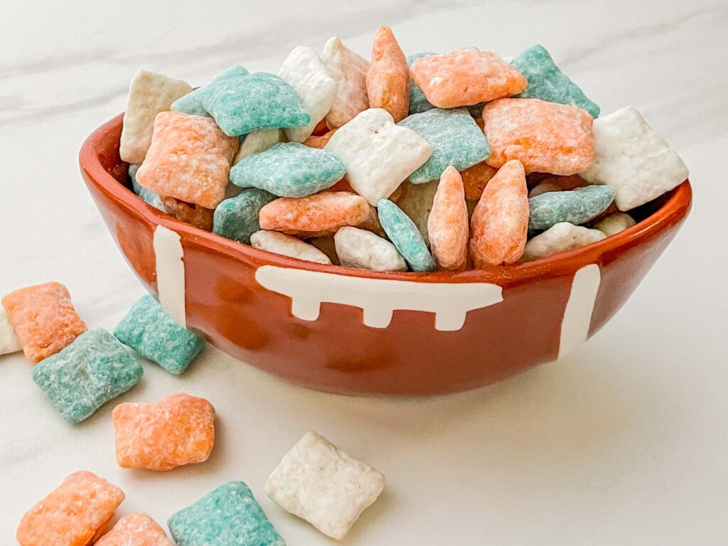 A football bowl of Miami Dolphins Puppy Chow on a counter.