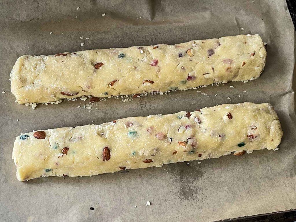 Dough shaped into two logs on a baking sheet before cooking.