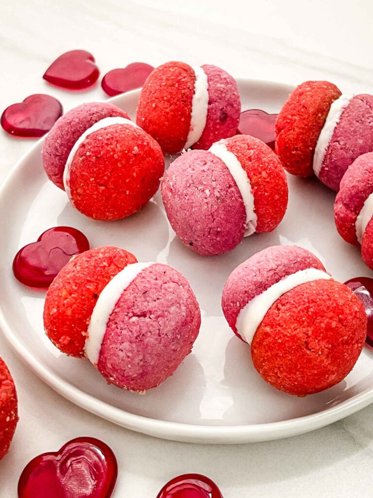 Pink and red Valentine's Day Baci di Dama Cookies on a white plate.