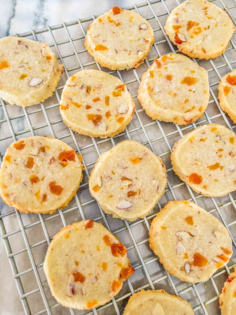 The Apricot Almond Shortbread Cookies spread out on a cooling rack on a counter.