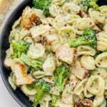 Looking down on a dark bowl full of tossed Copycat Olive Garden Chicken con Broccoli pasta.