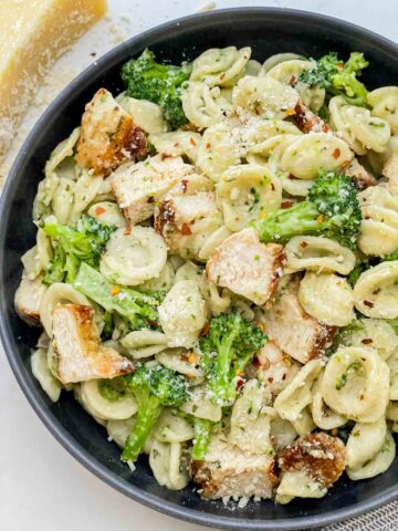 Looking down on a dark bowl full of tossed Copycat Olive Garden Chicken con Broccoli pasta.