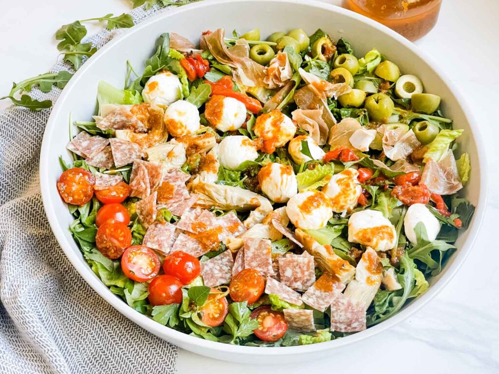 A large bowl full of the Best Italian Chopped Salad Recipe with ingredients in rows.