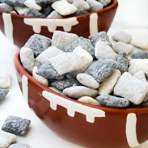 Two football bowls on a counter full of black, silver and white Las Vegas Raiders Puppy Chow.