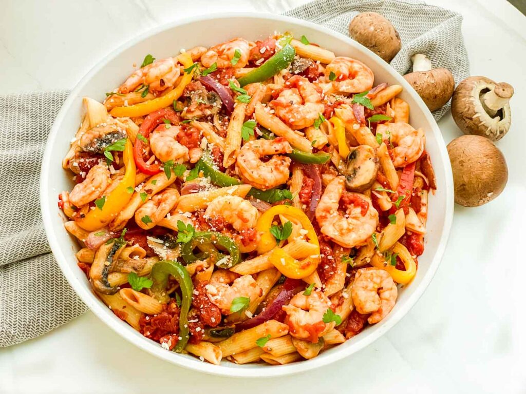 Looking down on a large bowl of Copycat Olive Garden Shrimp Primavera Pasta on a counter.