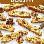 Pin of Italian Fig Walnut Biscotti cookies spread out on a counter with title.