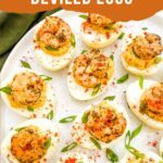 Pin of Cajun Shrimp Deviled Eggs on a white plate with title at top.