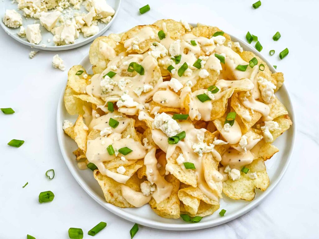 A plate of Copycat Bennigan's Blue Cheese Chips on a white counter.