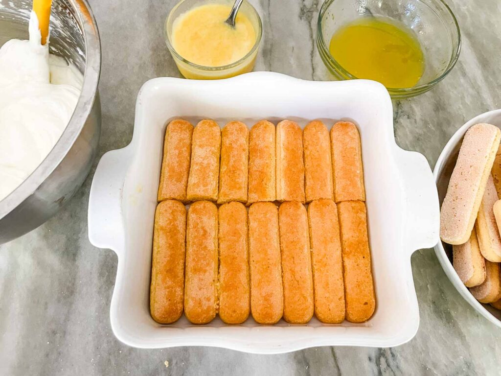 A square dish with the bottom layer of lady fingers inside.