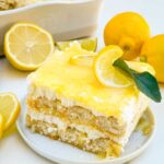 A closer view of a slice of Limoncello Tiramisu with the distinct layers, on a small plate.