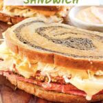 Pin of a whole Pastrami Reuben Sandwich Recipe on a board with title.