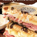 Pin of a cut Pastrami Reuben Sandwich Recipe stacked up with title.