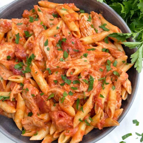 Looking down on a bowl of Chicken alla Vodka Pasta with fresh parsley.