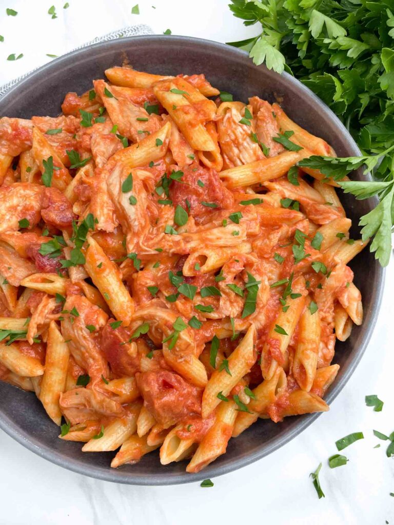 Looking down on a bowl of Chicken alla Vodka Pasta with fresh parsley.