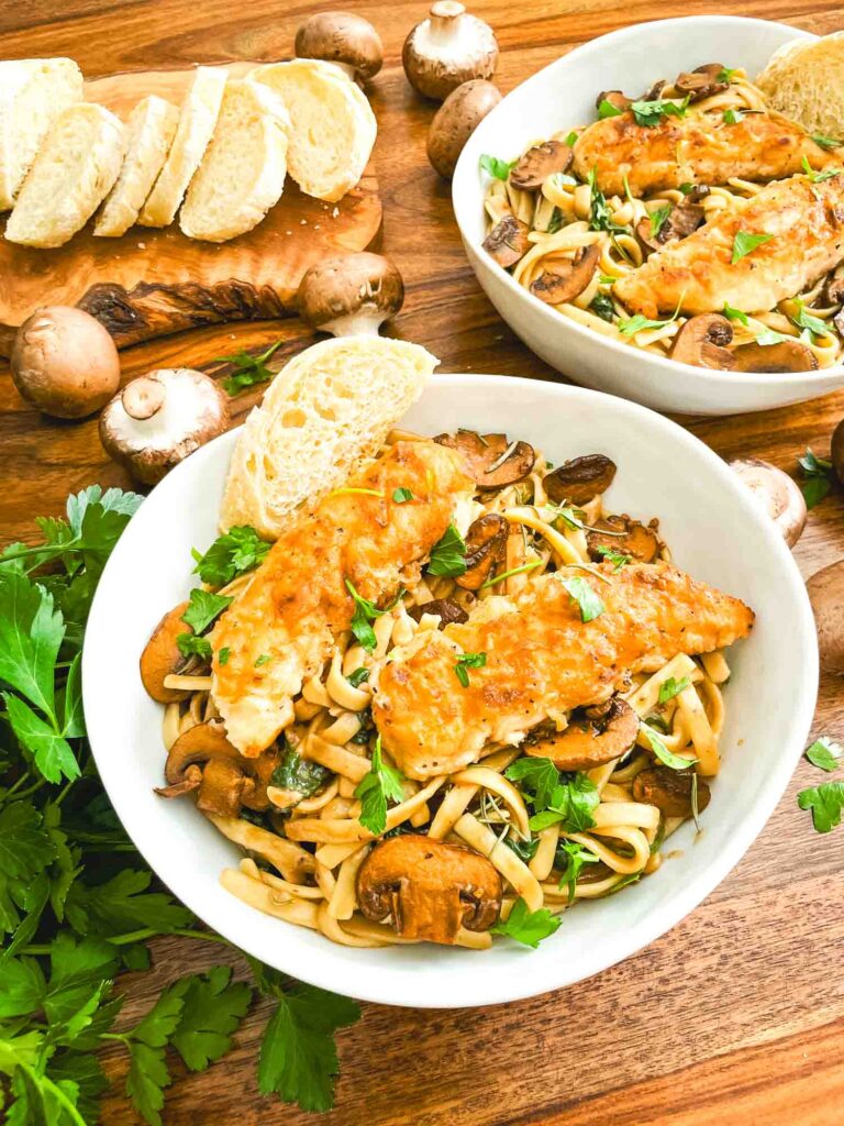 Looking down on a bowl of Copycat Olive Garden Chicken Marsala Fettuccine pasta on a table.