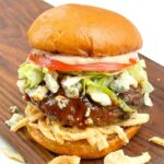 A Copycat Red Robin Bleu Ribbon Burger sitting on a wood board.