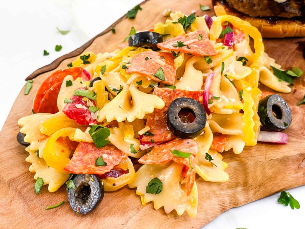 A pile of Italian Pasta Salad with Pepperoni on a wood board.