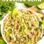 Pin looking down on Creamy Avocado Coleslaw (without Mayo) in a bow on a wood board with title at top.
