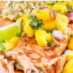 Pin of flaky Salmon with Mango Salsa with title at top.