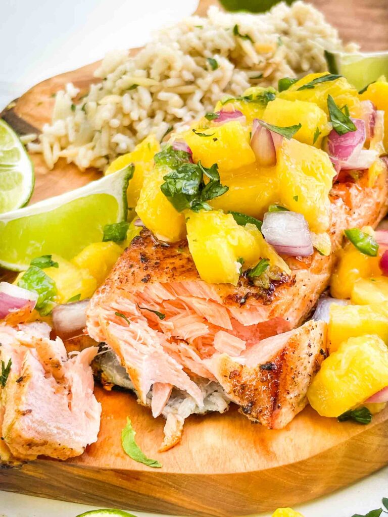 A piece of Salmon with Mango Salsa partially eaten.