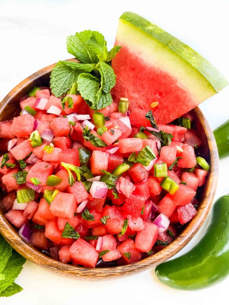 Looking down on Watermelon Salsa in a wood bowl on a counter.