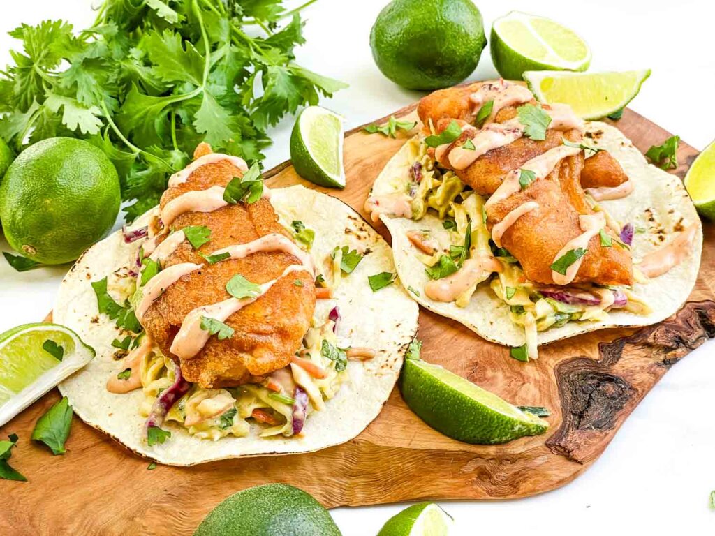 Two Fresh Baja Fish Tacos on a wood board.