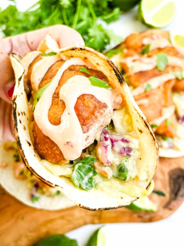 A hand holding a Fresh Baja Fish Taco.