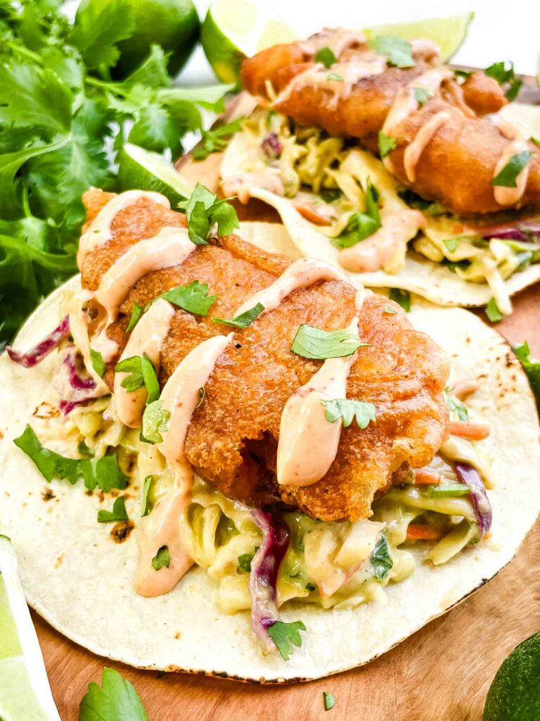 A closer view of a Fresh Baja Fish Taco on a wood board.