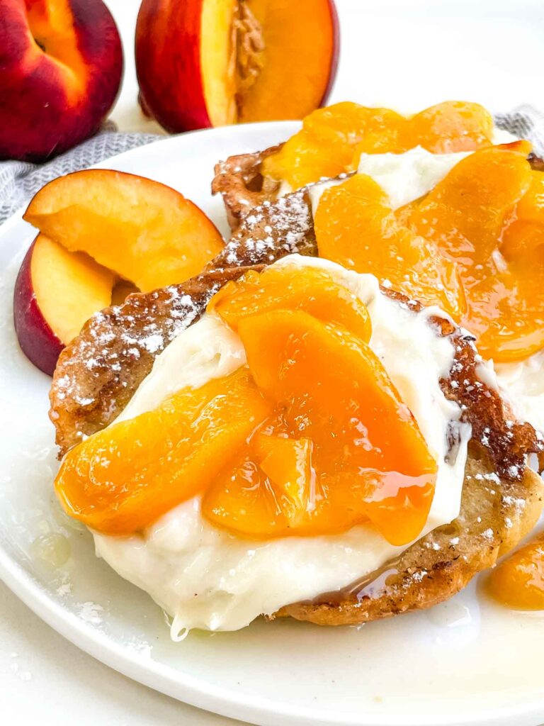Closer view of Peaches and Cream French Toast on a white plate.