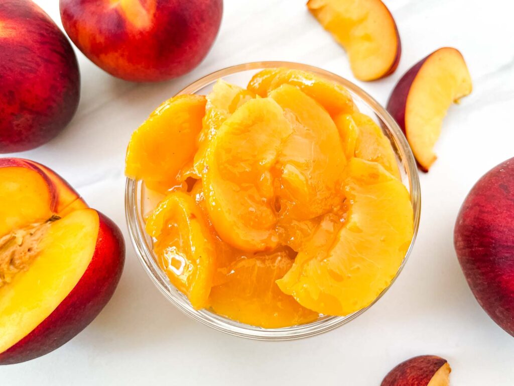 Looking down on a small glass bowl full of Easy Peach Dessert Sauce on a counter.