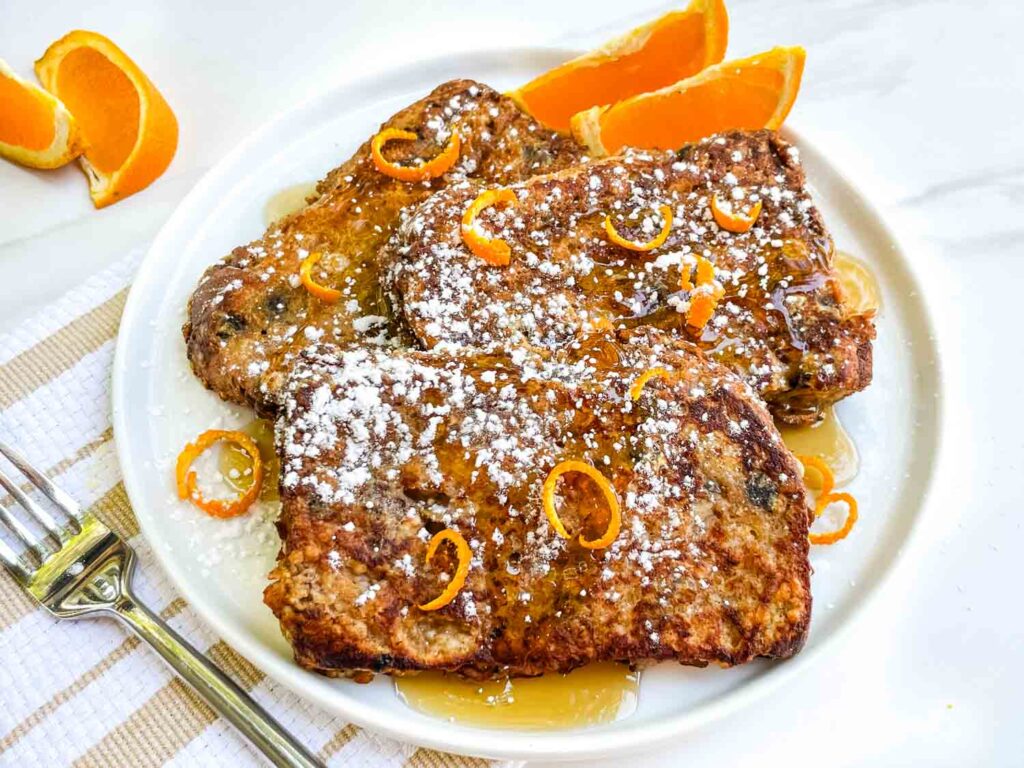 Slices of Panettone French Toast Recipe on a white plate on a counter.