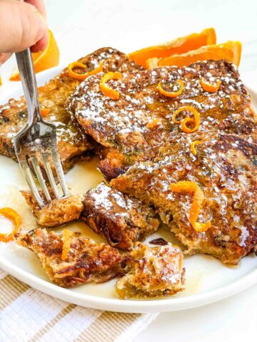 A fork digging into cut up Panettone French Toast Recipe on a plate.