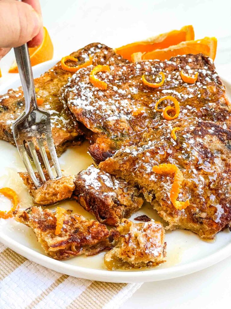 A fork digging into cut up Panettone French Toast Recipe on a plate.