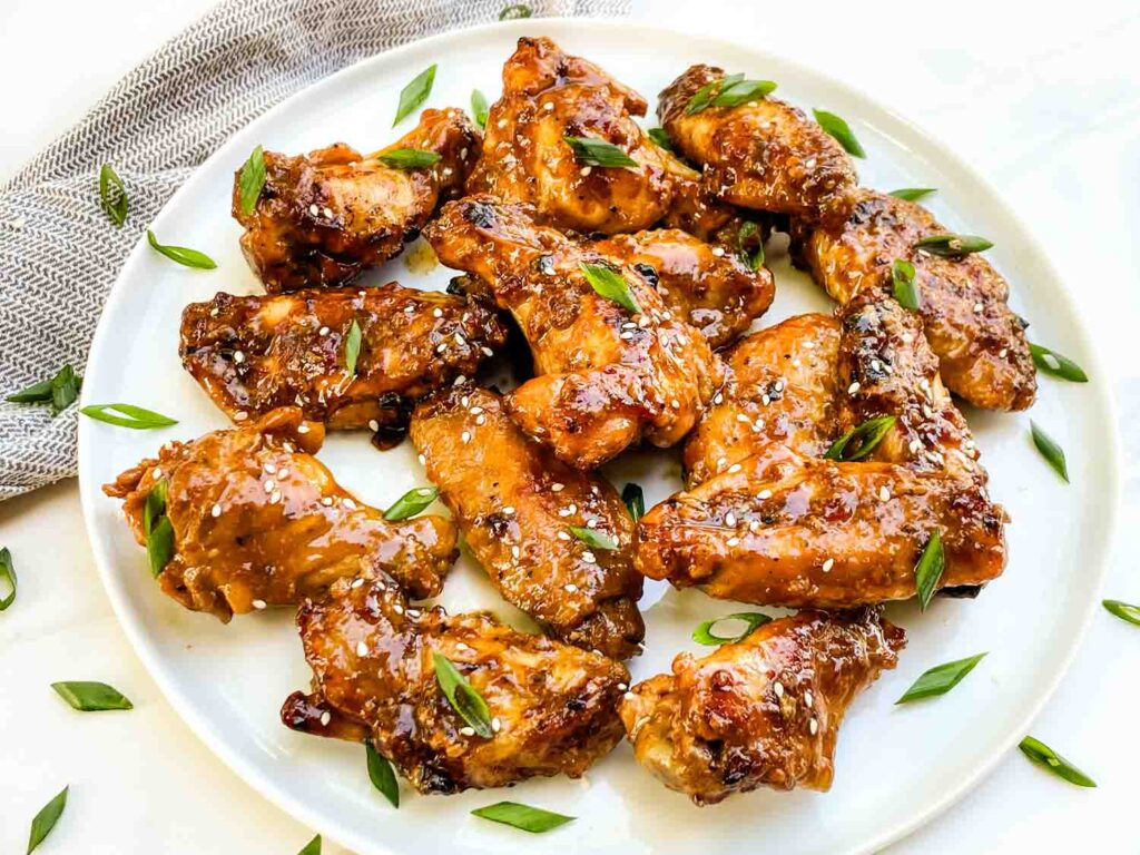 A white plate filled with a pile of Thai Chicken Wings.
