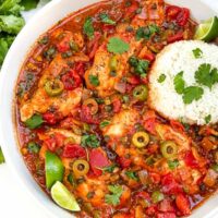 Looking down on Chicken Veracruz (Pollo a la Veracruzana) in a large dish with some rice.