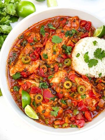 Looking down on Chicken Veracruz (Pollo a la Veracruzana) in a large dish with some rice.