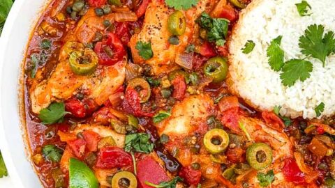 Looking down on Chicken Veracruz (Pollo a la Veracruzana) in a large dish with some rice.