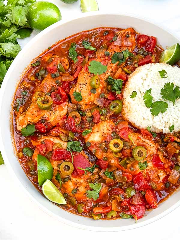 Looking down on Chicken Veracruz (Pollo a la Veracruzana) in a large dish with some rice.