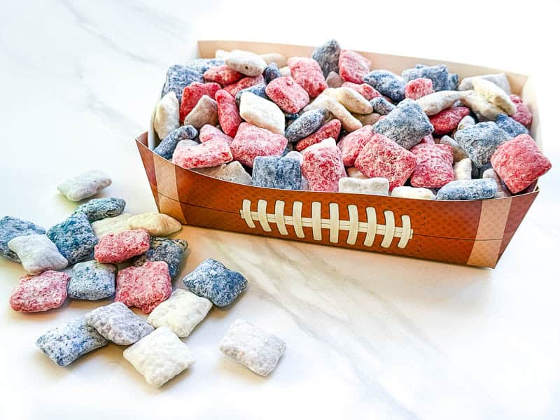 A pile of New England Patriots Puppy Chow in a football tray on a white counter.