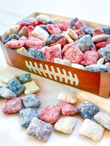 New England Patriots Puppy Chow in red, blue, white, and gray in a football container on a counter.