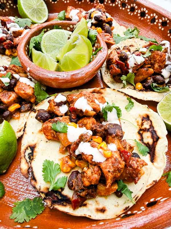 A close view of a Southwest Chipotle Chicken Taco in a tray with limes.