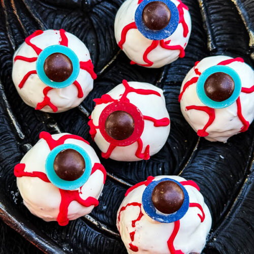 A close view of Halloween Eyeball Cake Pops on a black tray.