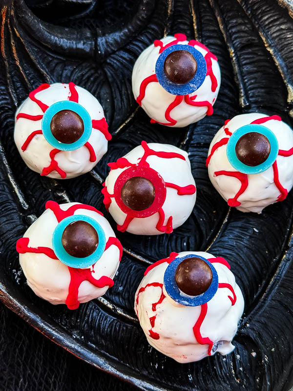 A close view of Halloween Eyeball Cake Pops on a black tray.