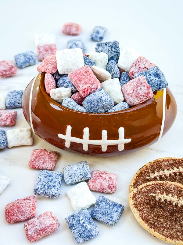 Red, blue, and white Houston Texans Puppy Chow in a small football bowl on a counter.